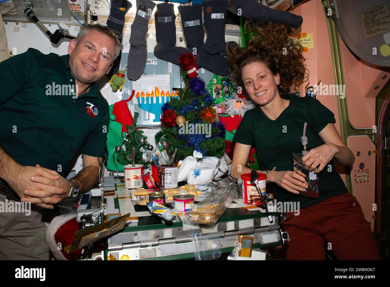 ISS - 25. Dezember 2023 - Expedition 70 Besatzungsmitglieder kommen im Einheitsmodul der Internationalen Raumstation zu einem Weihnachtsessen zusammen. Komma Stockfoto