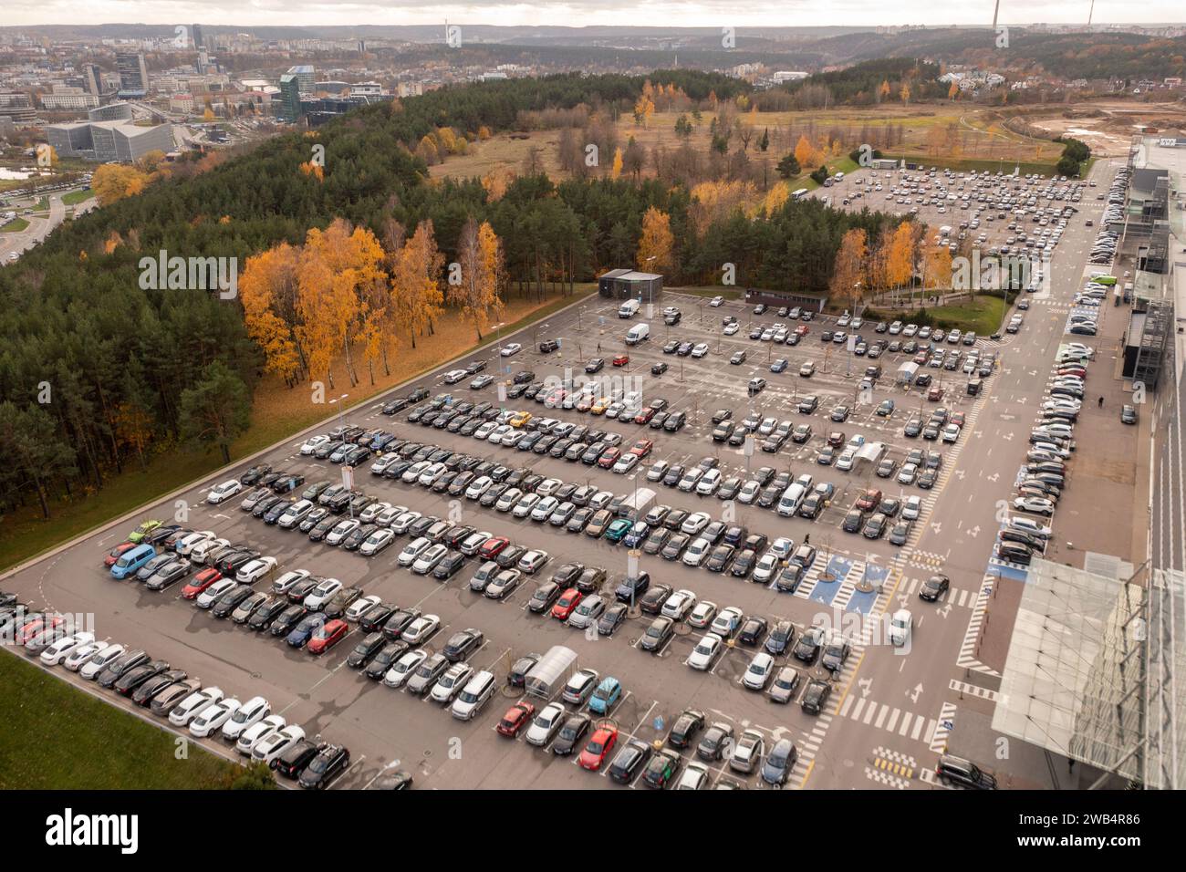 Drohnenfotografie eines großen Parkplatzes in der Nähe eines Einkaufszentrums an sonnigen Herbsttagen Stockfoto