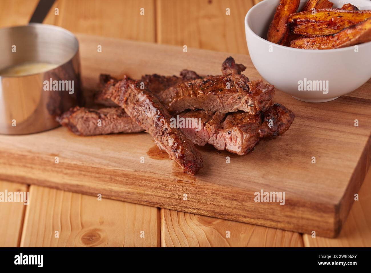 Saftiges Rindersteak mit Kartoffelscheiben und Pilzsteak-Sauce. Stockfoto