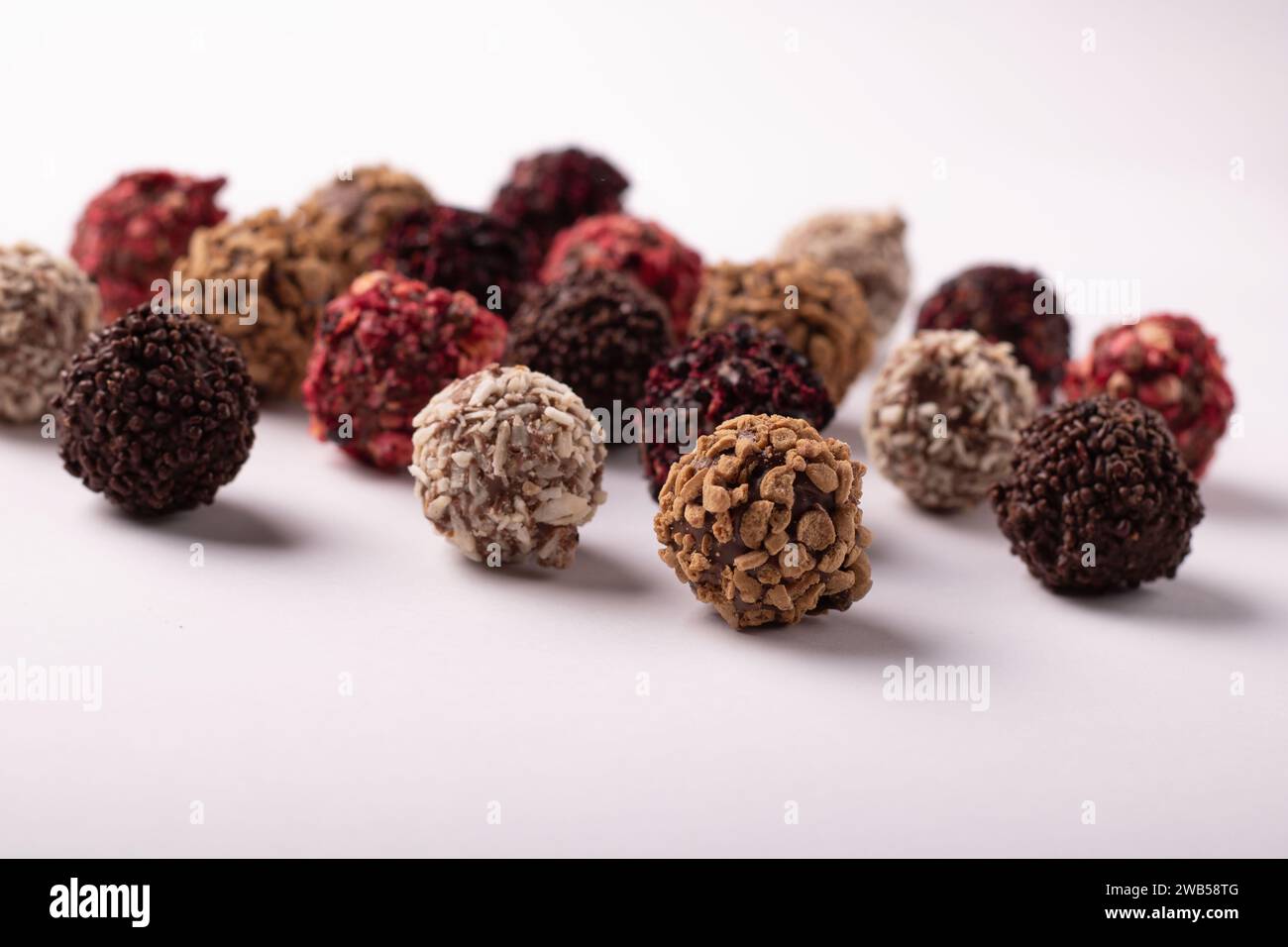 Auf diesem horizontalen Foto steht ein köstliches Schokoladensortiment vor einem strahlend weißen Hintergrund im Mittelpunkt. Das verlockende Versprechen Stockfoto