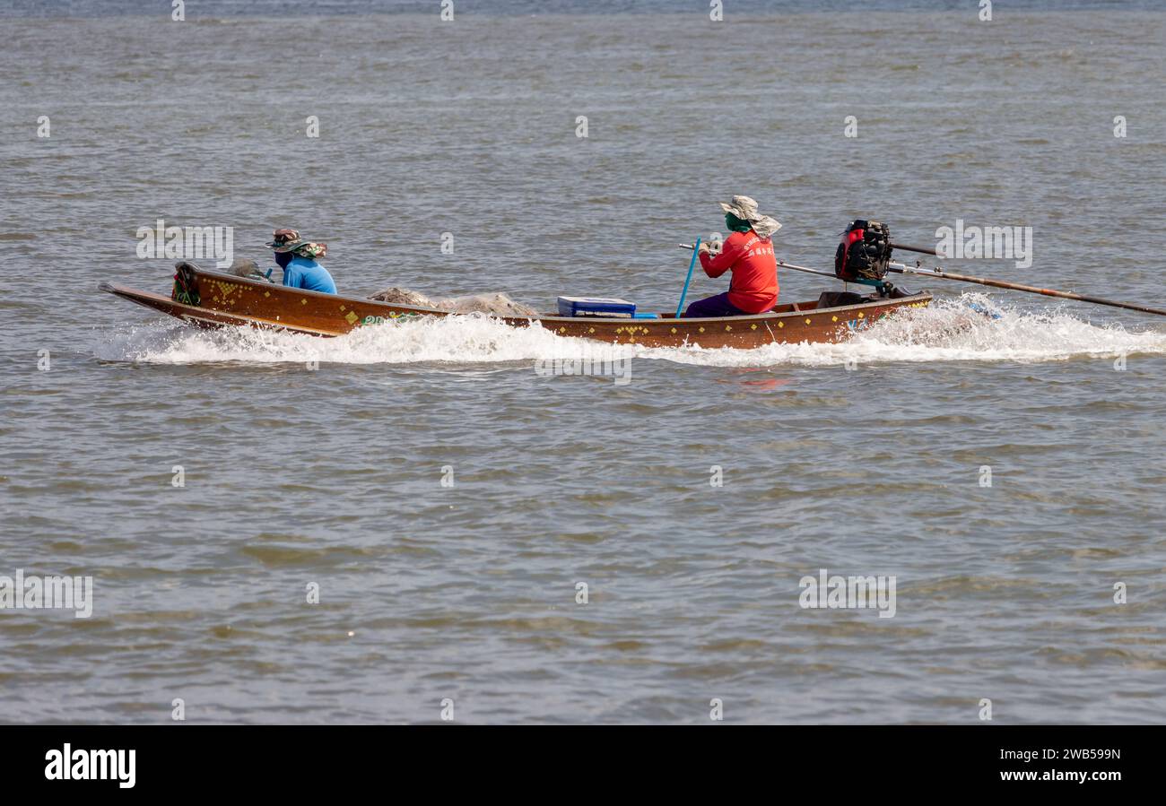 SAMUT PRAKAN, THAILAND, 15. Dezember 2023, asiatische Fischer segeln auf einem Boot mit einem Fischernetz Stockfoto