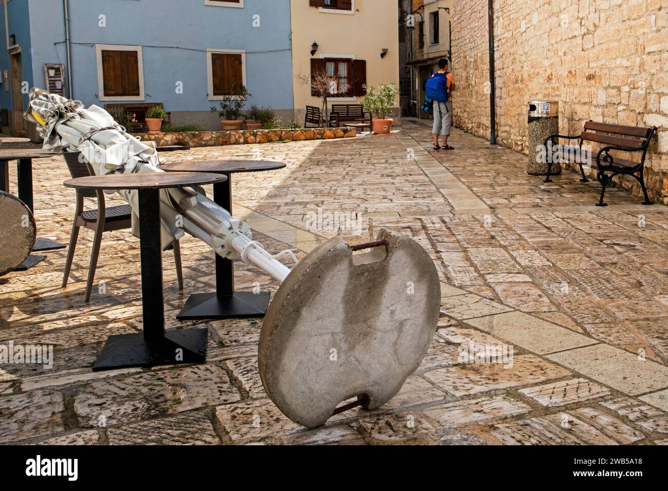 Der gefallene Schirm liegt bei Regen in einem Café im Innenhof auf den Tischen. Europa-Tour Stockfoto