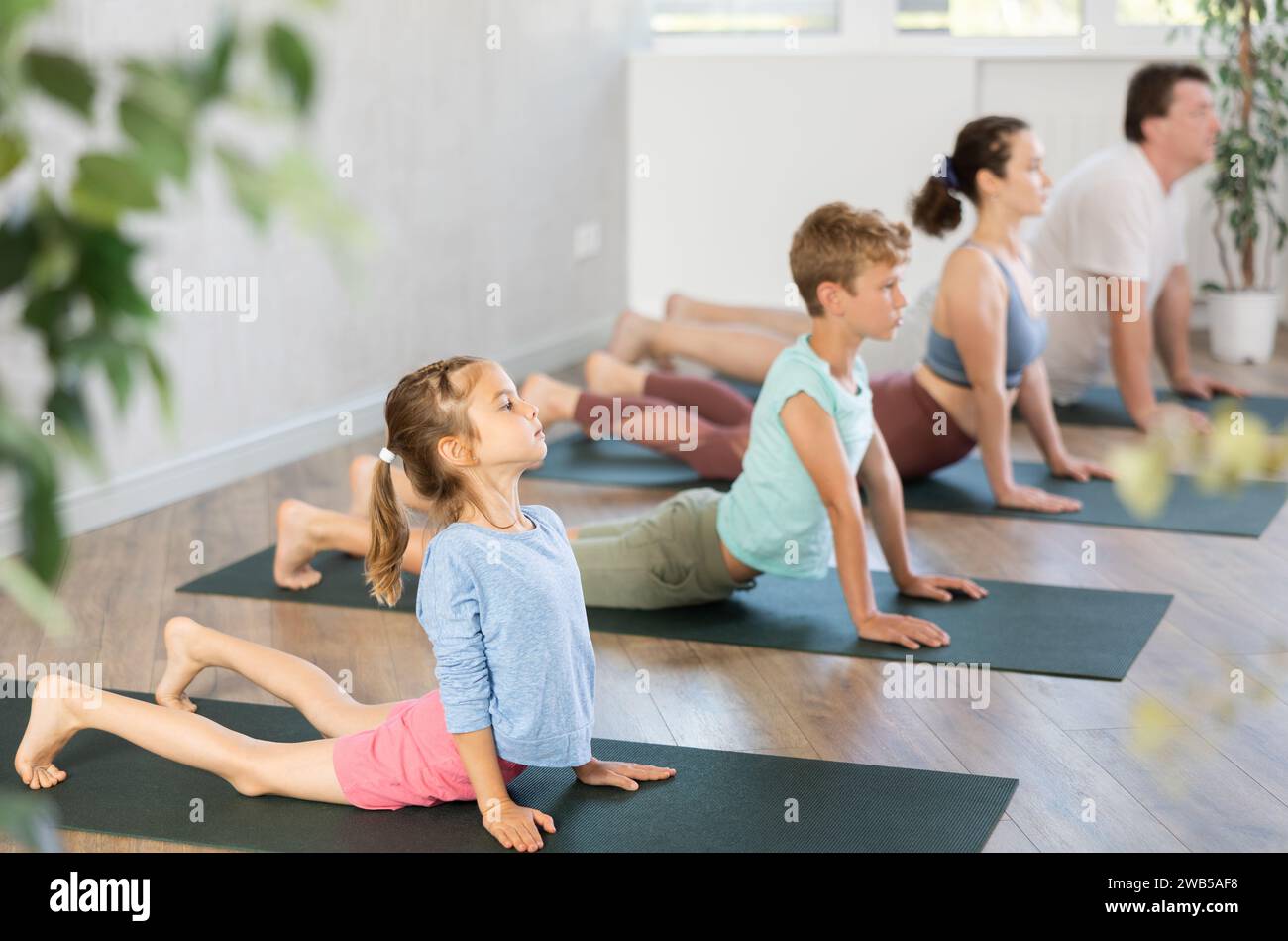 Familie mit zwei Kindern, die Yoga im Studio machen Stockfoto