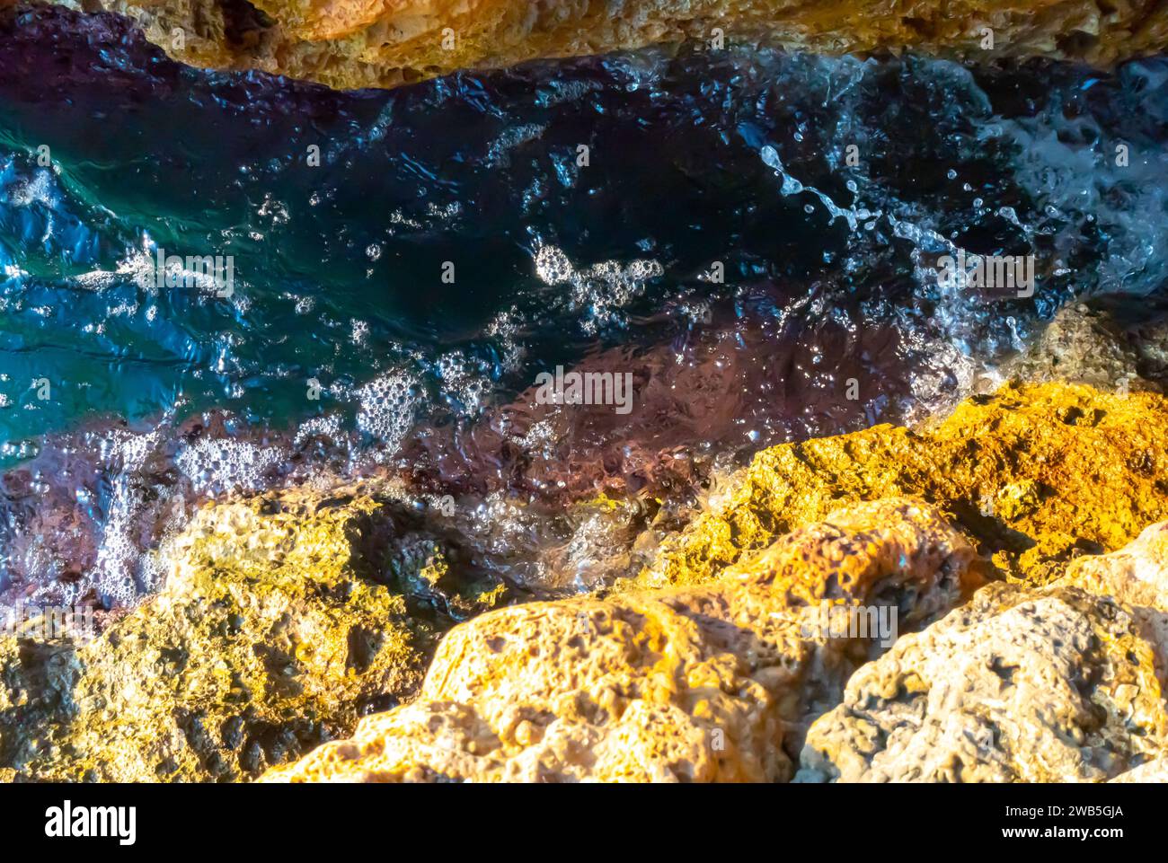 Schaumige Felsenriffe, Klippenfelsen gelb, mediterranes Wasser von Antalya türkei felsige Klippen, Wasserschaum poröse Steine verwittert Stockfoto