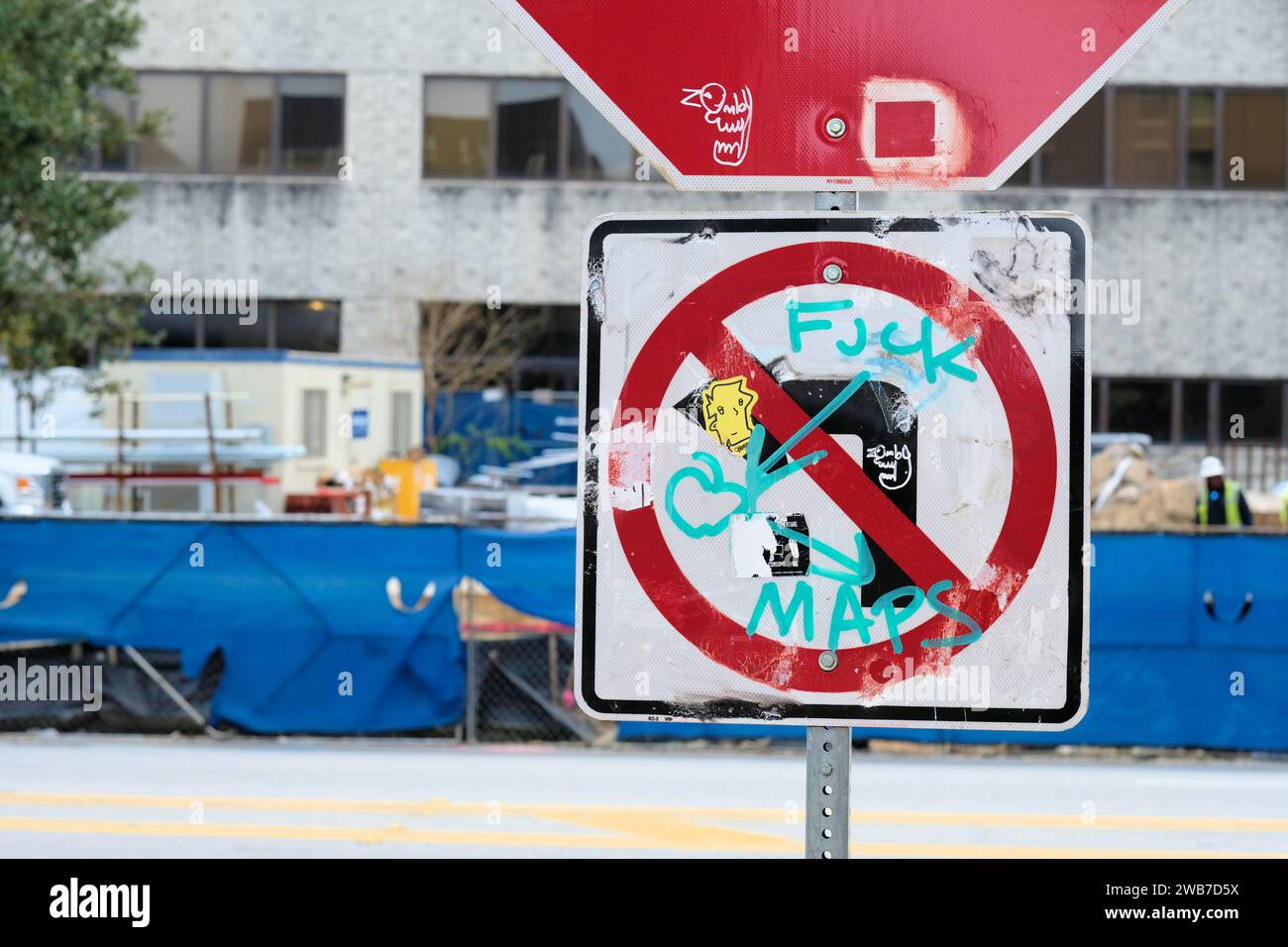 Stoppschild mit einem Schild „nicht links abbiegen“ und Graffiti kritisch für Web-Mapping-Dienste, um Fahrer anzuweisen, dort links abzubiegen, wo es verboten ist. Stockfoto