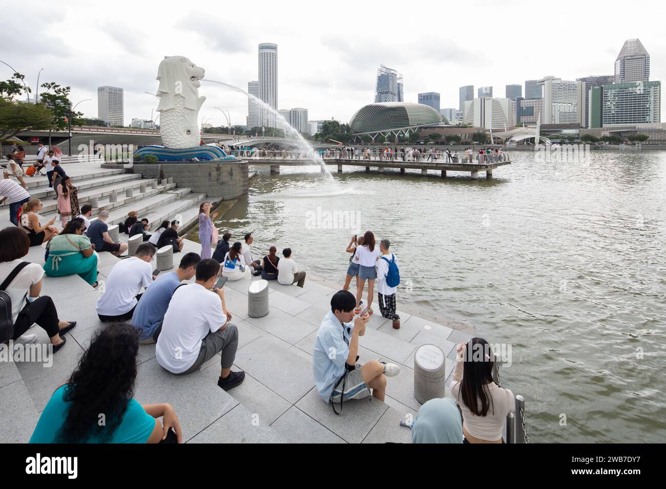Touristen aus der ganzen Welt sind zurück zum beliebten Wahrzeichen Merlion im Merlion Park, Marina Bay Viertel. Singapur. 2024 Stockfoto