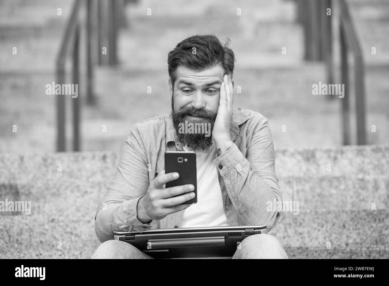 Verlierer beim Wetten. Frustrierter Mann verlor die mobile Wette. Wetten über ein mobiles Gerät abschließen. Online-Wetten Stockfoto