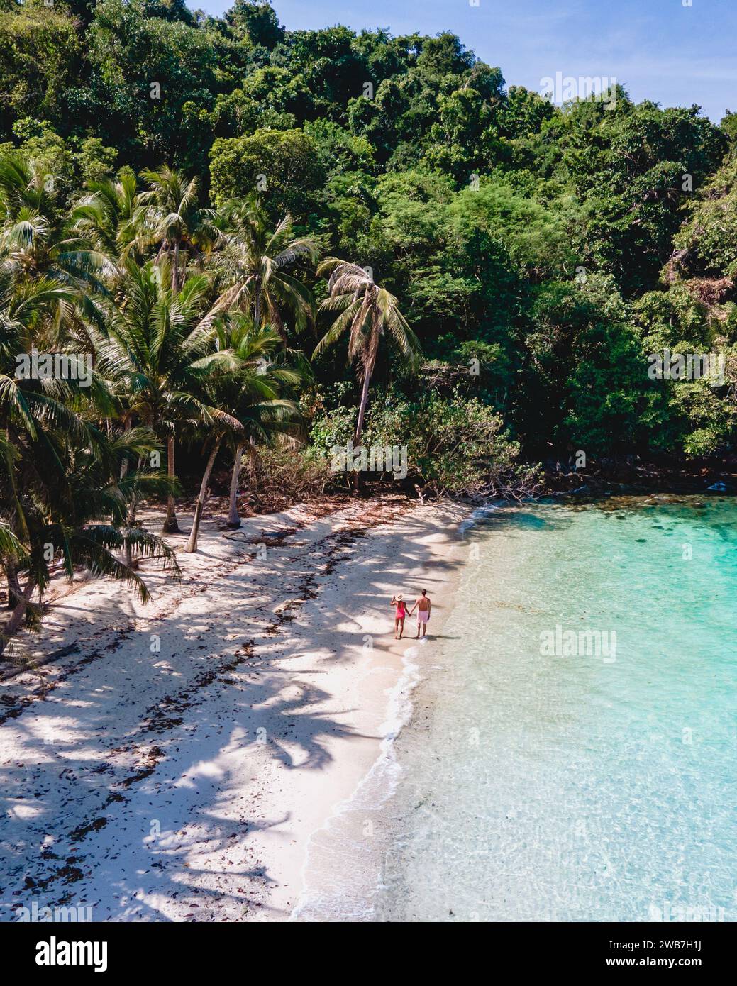 Drohnenblick auf Koh Wai Island trat Thailand. Ein junges Paar Männer und Frauen, die während eines Luxusurlaubs in Thailand an einem tropischen Strand spazieren gehen Stockfoto