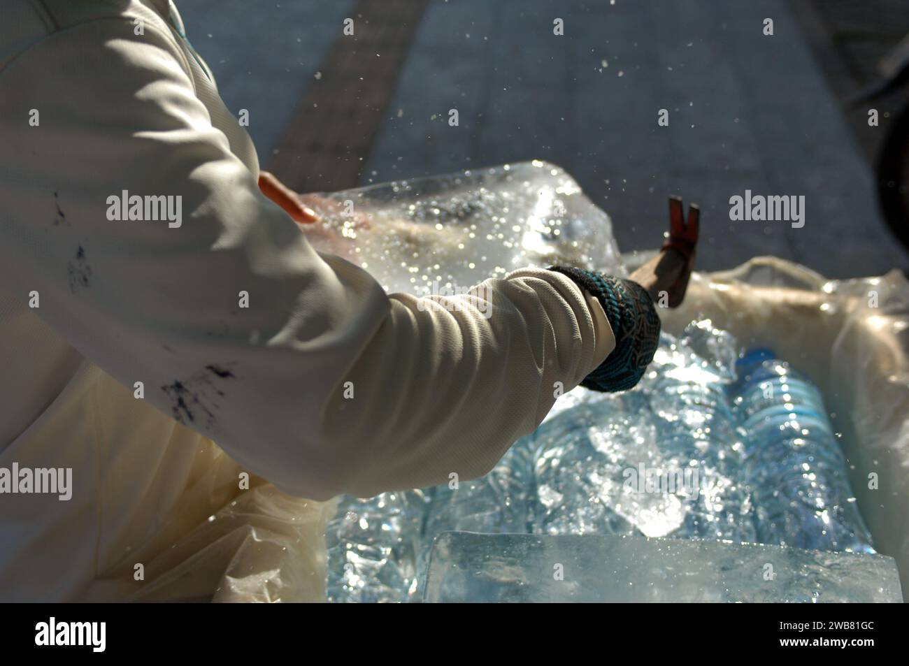 Frau, die mit einer Axt einen Eisblock bricht, Siem Reap, Kambodscha. Stockfoto