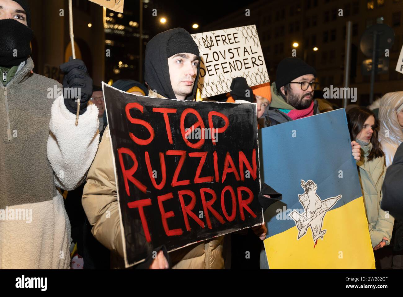 Ein Demonstrant hält ein Schild mit der Aufschrift STOP RUZZIAN TERROR