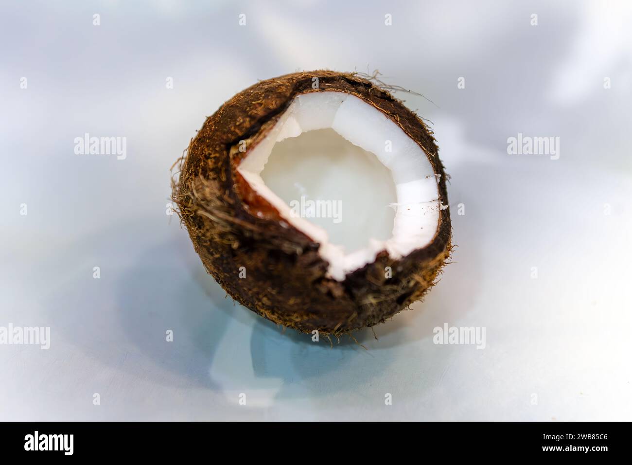Frische Kokos. Nahaufnahme von gebrochener Kokosnuss auf dem Tisch. Geringe Schärfentiefe. Stockfoto