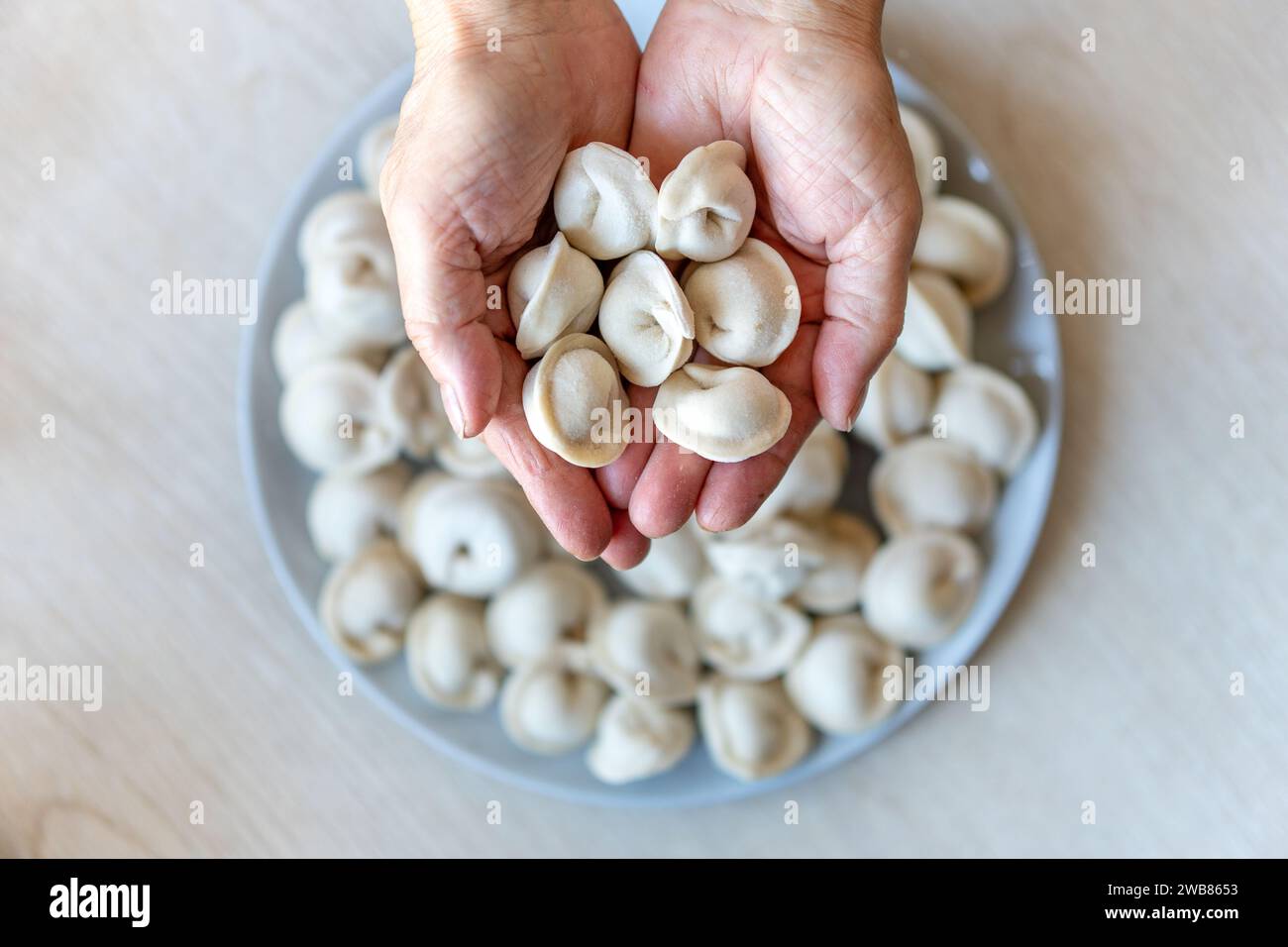 Hände machen Klöße, Hände kneten Teig, Bäcker, Bäcker Hände, Teig, Hände im Mehl, Klöße, handgemachte Klöße, Ravioli Blick von oben, Stockfoto