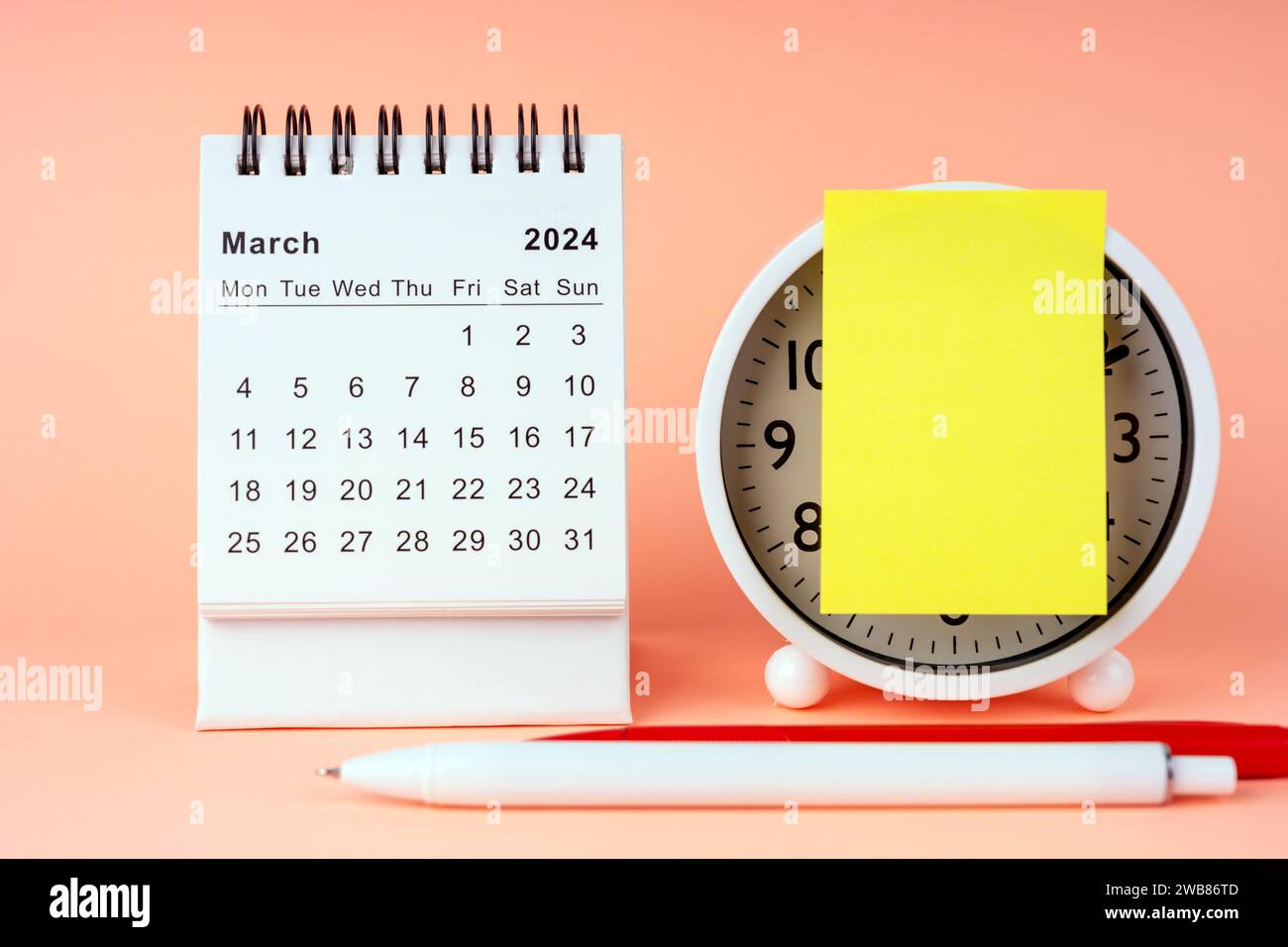 März 2024 Schreibtischkalender mit Wecker und Haftnotiz Stockfoto