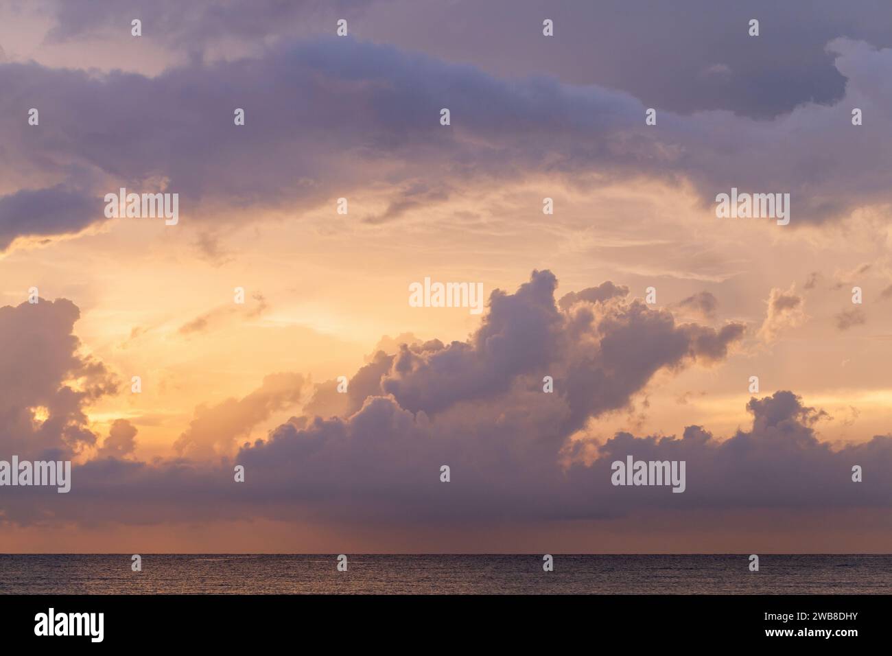 Farbenfrohe Wolken des tropischen Himmels über dem Ozean bei Sonnenuntergang, natürliches Hintergrundfoto Stockfoto