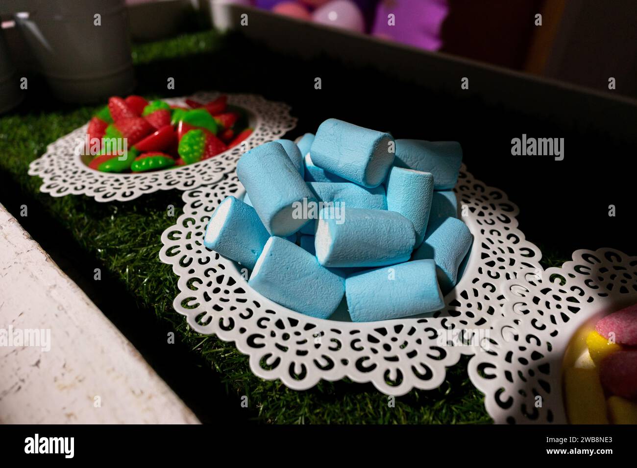 Farbenfrohe blaue Marshmallow-Süßigkeiten auf einem Teller, die eine süße Note für eine Geburtstagsfeier verleihen. Stockfoto