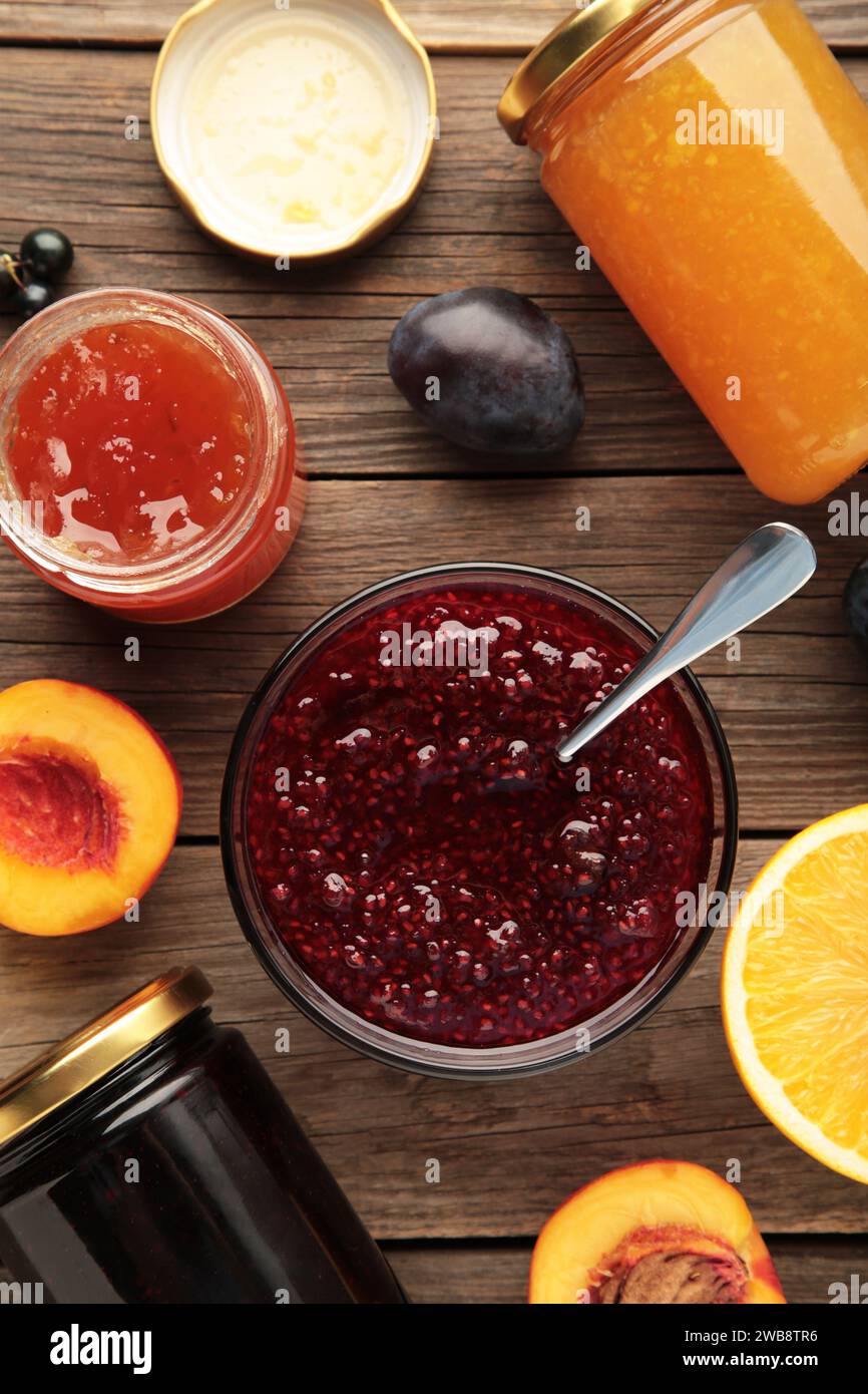 Auswahl an Marmeladen, frischen Beeren der Saison und Obst auf grauem Hintergrund. Vertikales Foto Stockfoto