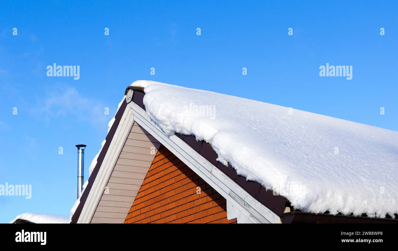 Schnee driftet auf dem Dach nach Schneefällen an sonnigen Tagen. Ländliche Winterlandschaft Stockfoto