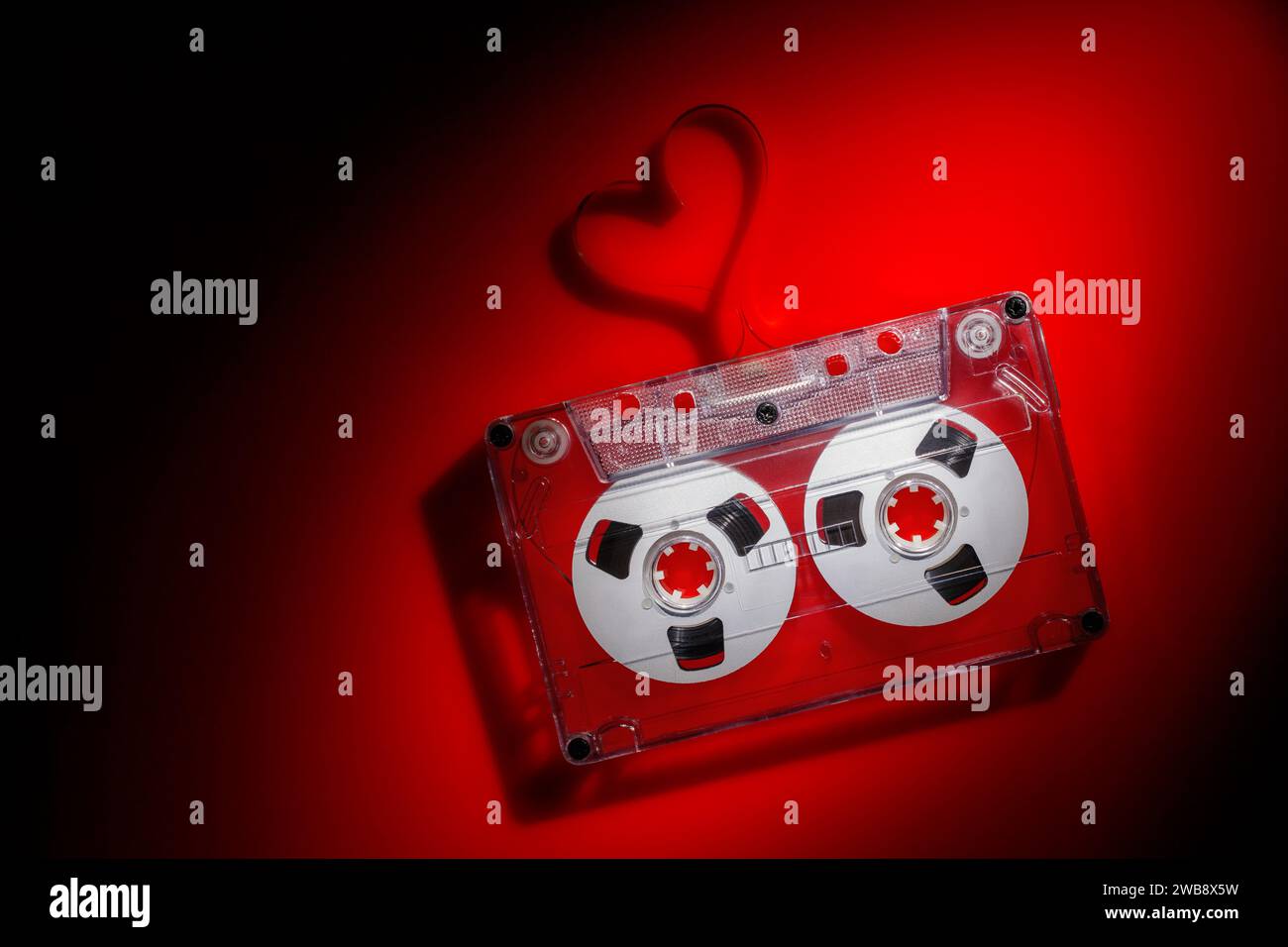 Valentinstag Hintergrund - Audiokassette mit herzförmigem Band in rotem Licht. Stockfoto