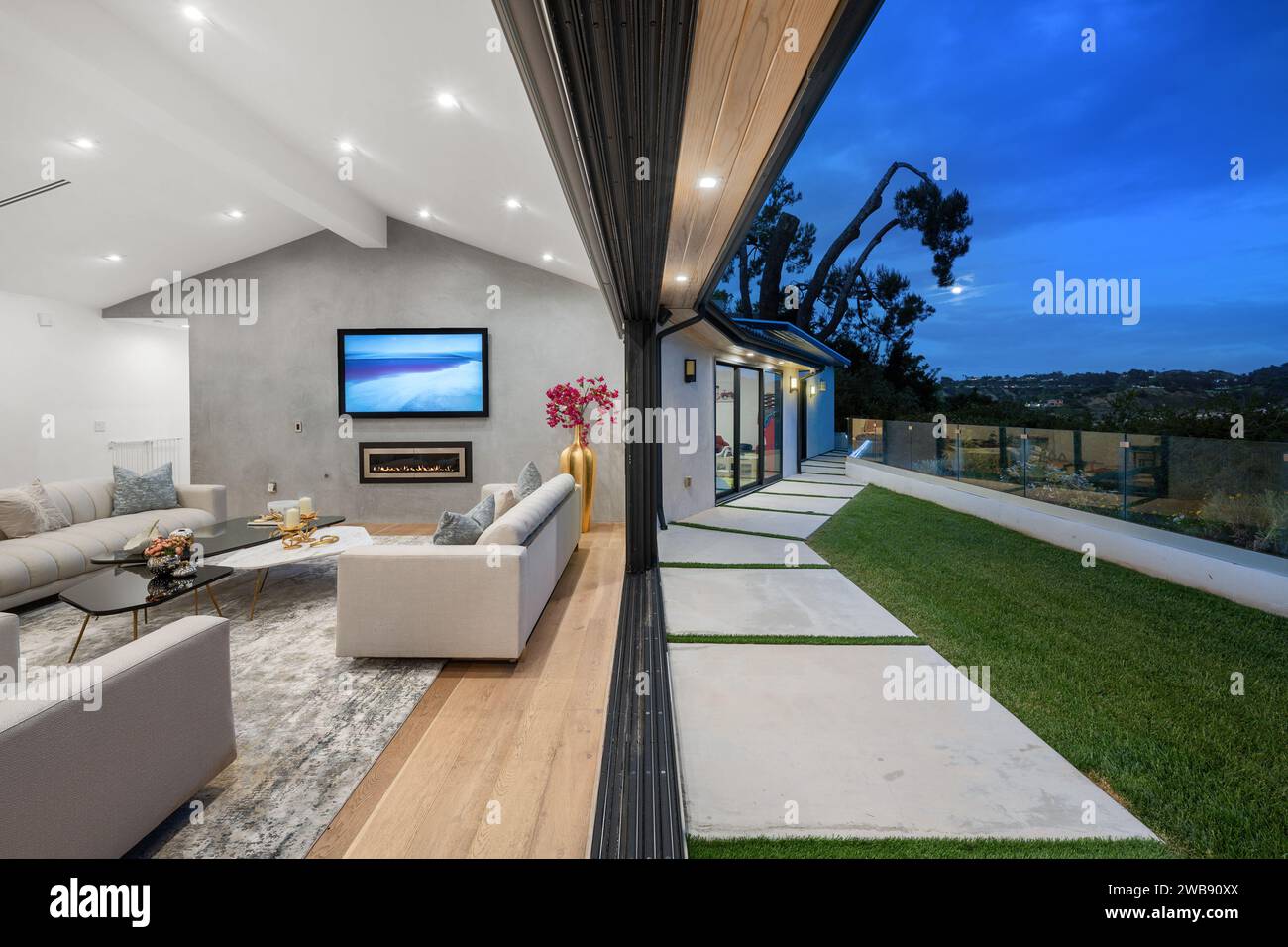 Dieses moderne Wohnzimmer verfügt über eine holzgetäfelte Decke, die eine elegante und einladende Atmosphäre vermittelt Stockfoto