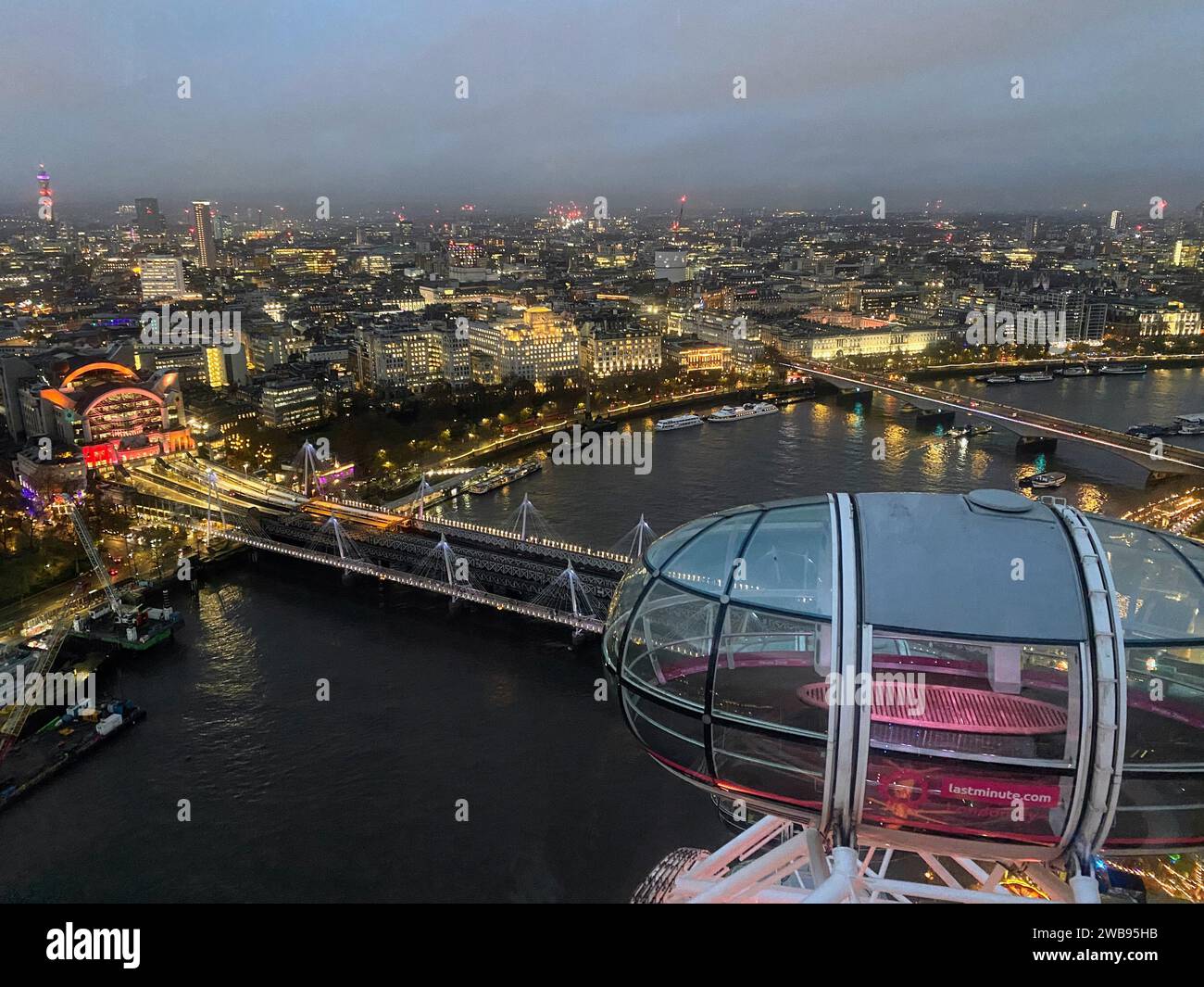 Blick aus der Vogelperspektive auf die Londoner Skyline bei Nacht, beleuchtet durch den Sonnenuntergang über der Themse, mit dem legendären London Eye Ferris Wheel Stockfoto