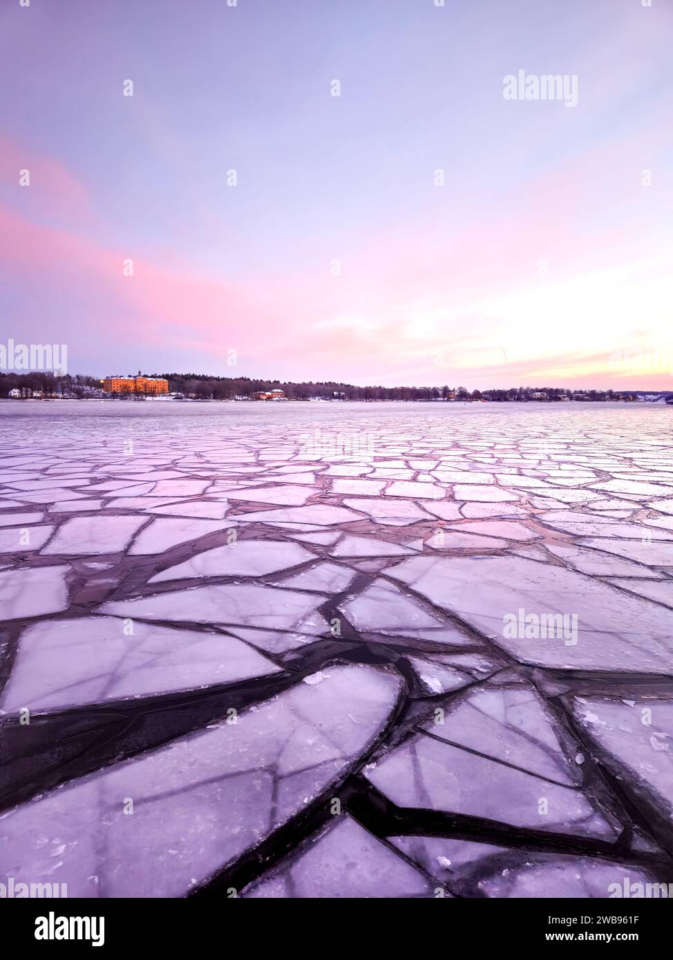 Eisschilde auf dem Meer im Winter bei Sonnenaufgang am frühen skandinavischen Morgen mit violettem und rosa Himmel in der schwedischen Hauptstadt Stockholm mit leichten Wolken am Himmel Stockfoto