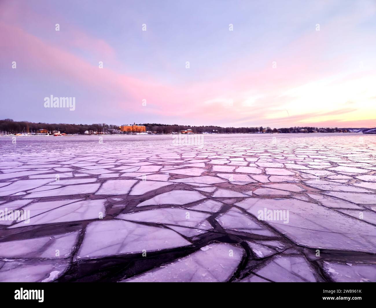 Eisschilde auf dem Meer im Winter bei Sonnenaufgang am frühen skandinavischen Morgen mit violettem und rosa Himmel in der schwedischen Hauptstadt Stockholm mit leichten Wolken am Himmel Stockfoto