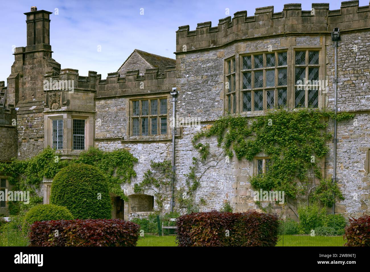Peak District, Bakewell, Derbyshire, England, Großbritannien - Haddon Hall mittelalterliches Herrenhaus mit zinnenverkleideten Wänden, Erkerfenstern und Schornsteinen Stockfoto