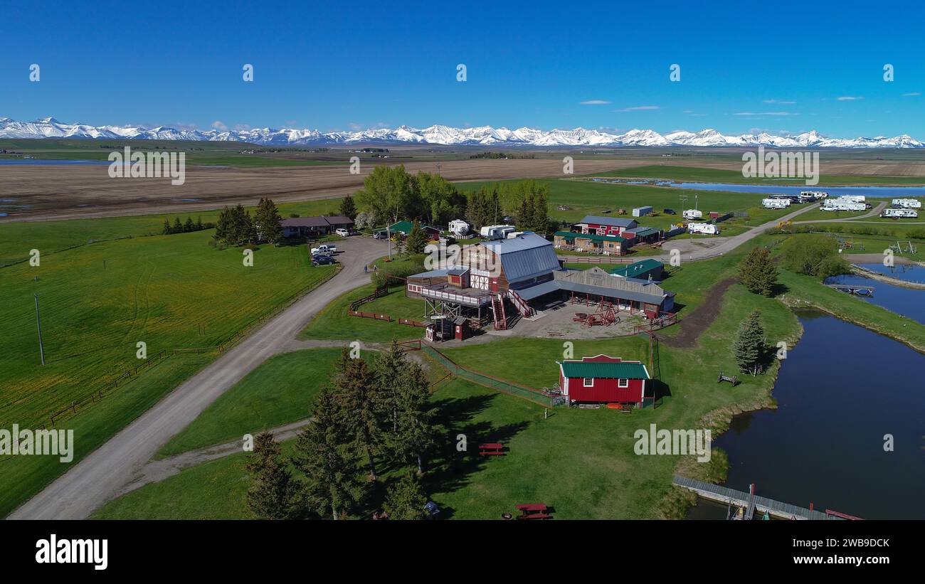 Panoramablick auf eine atemberaubende Landschaft mit einem sich windenden Fluss und charmanten Häusern vor der Kulisse majestätischer Bergketten Stockfoto