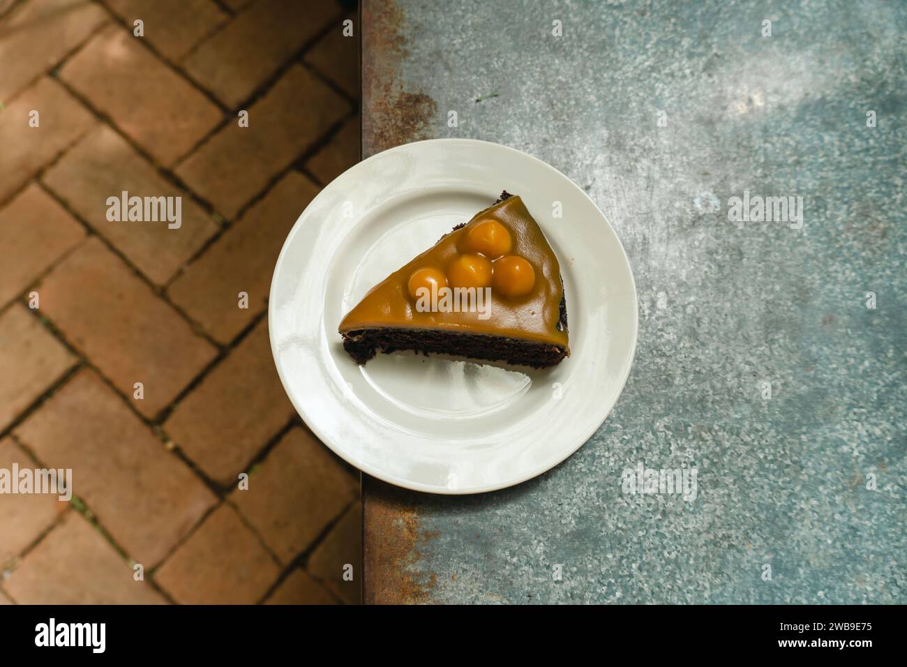Karamell-Macadamia-Schokoladenkuchen. Nahaufnahme eines kleinen süßen dekorativen Kuchens. Freier Platz für Text. Menü-Café und Café-Bar. Frischer, hausgemachter MacAdam Stockfoto