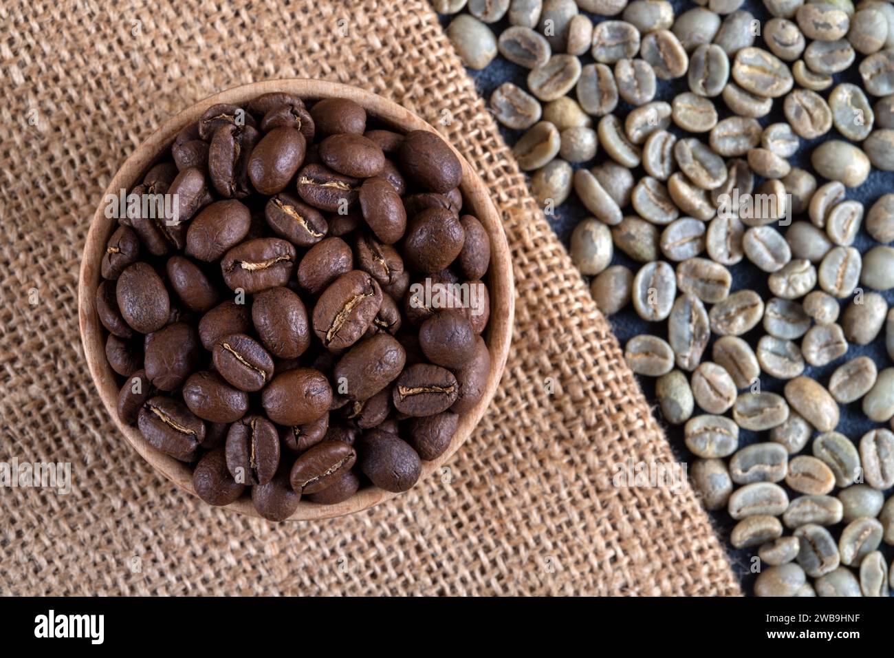 Grüner Kaffee mit gerösteten Kaffeebohnen auf Sack, Blick von oben Stockfoto