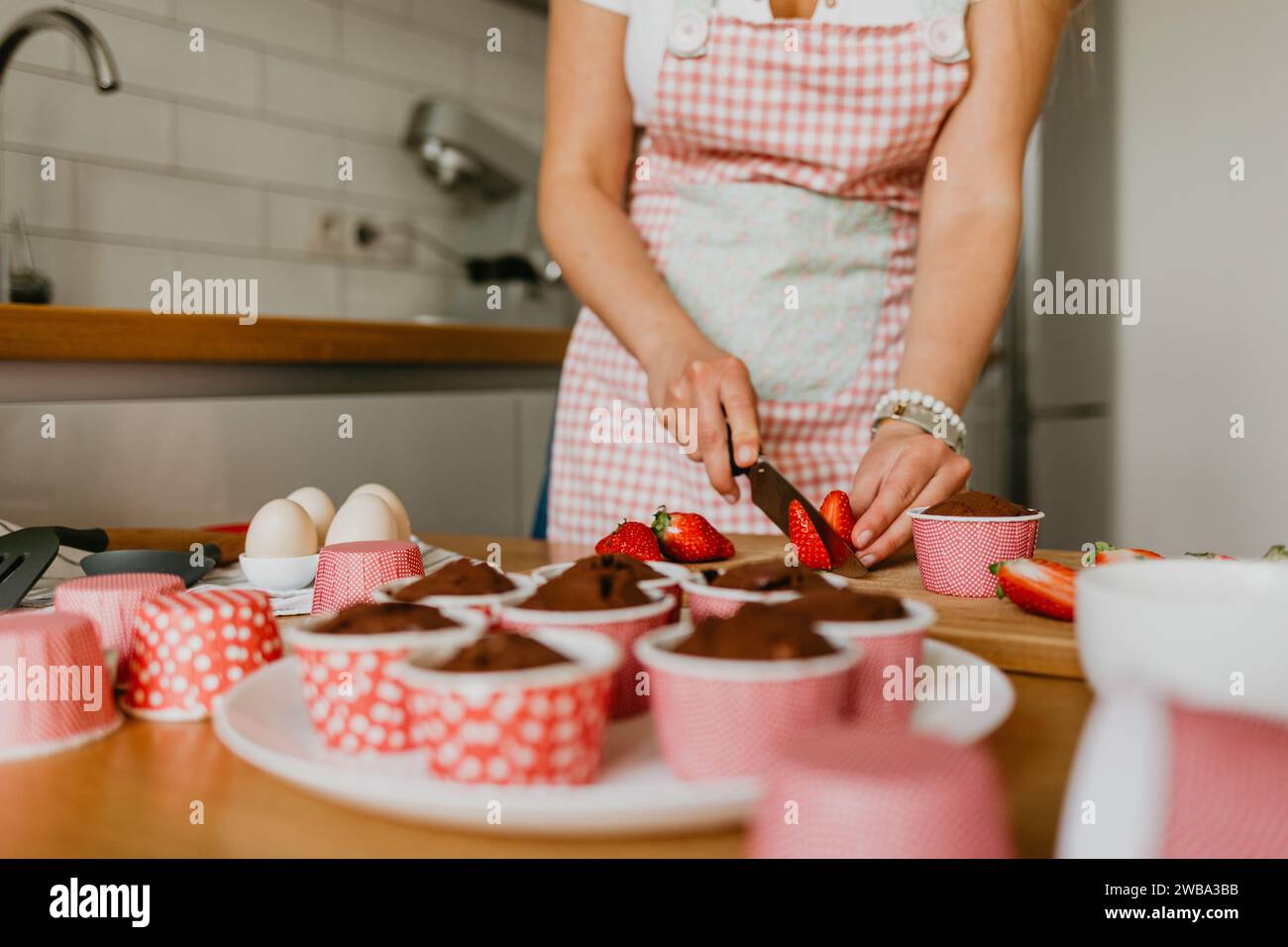 Eine junge Frau, die einen frisch gebackenen Cupcake hält. Stockfoto