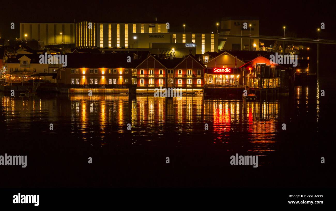 Beleuchtete Gebäude am Wasser bei Nacht in Svolvaer, Norwegen, Skandinavien, Europa im Oktober Stockfoto