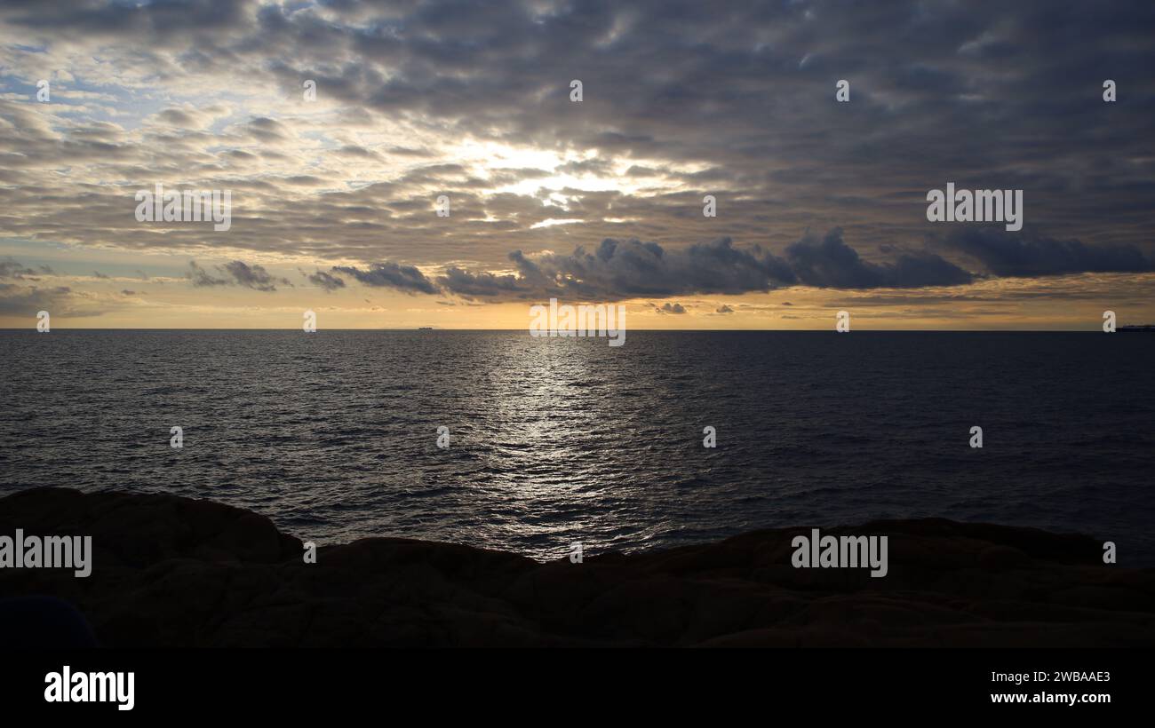 Sonnenuntergang über dem Meer in Italien mit Sonne hinter den Wolken Stockfoto