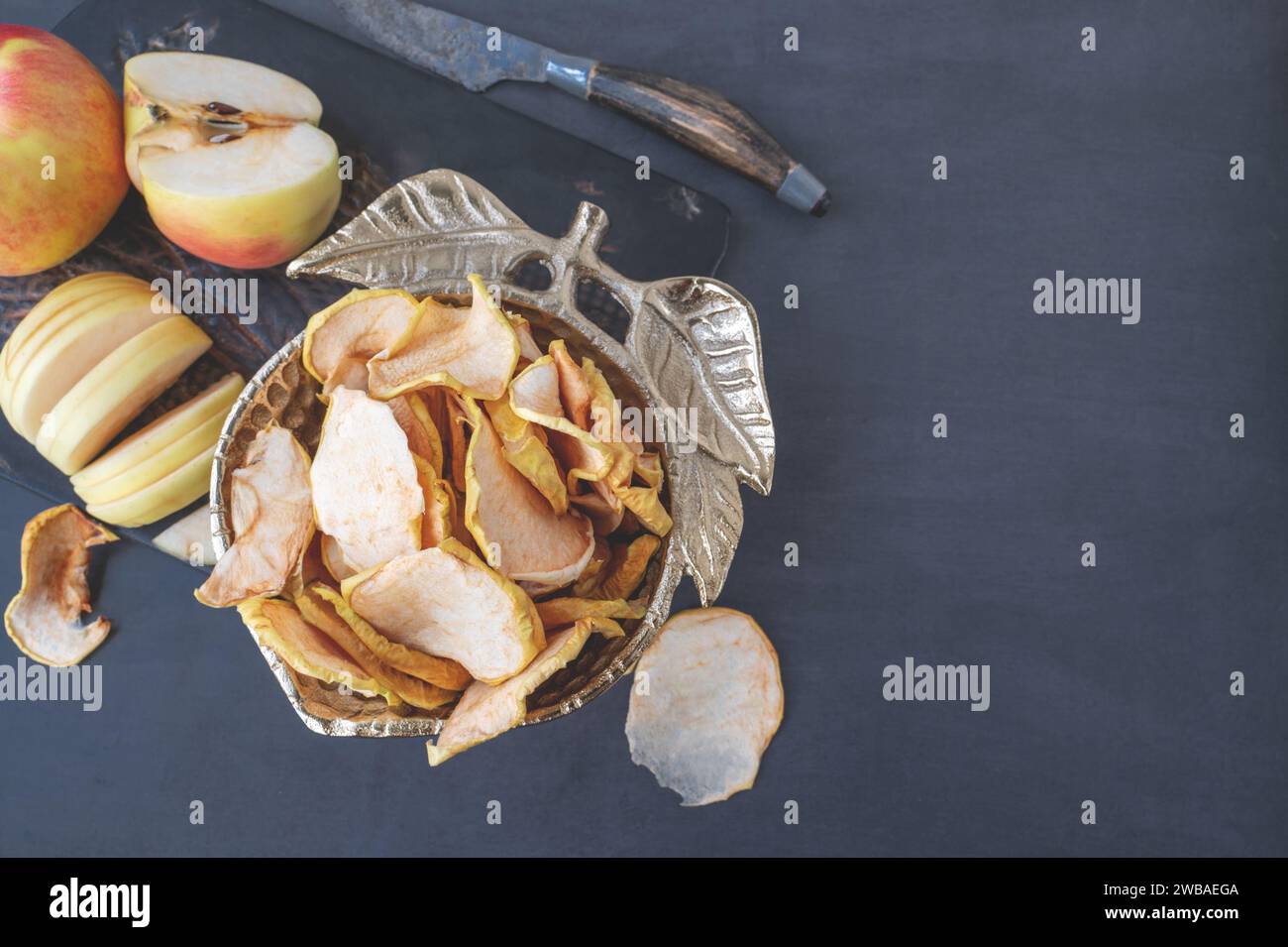 Getrocknete Apfelchips in einer Schüssel. Dehydrierte Äpfel. Hausgemachte getrocknete Apfelscheiben aus biologischem Anbau. Draufsicht, flach, Nahaufnahme. Kopierbereich Stockfoto