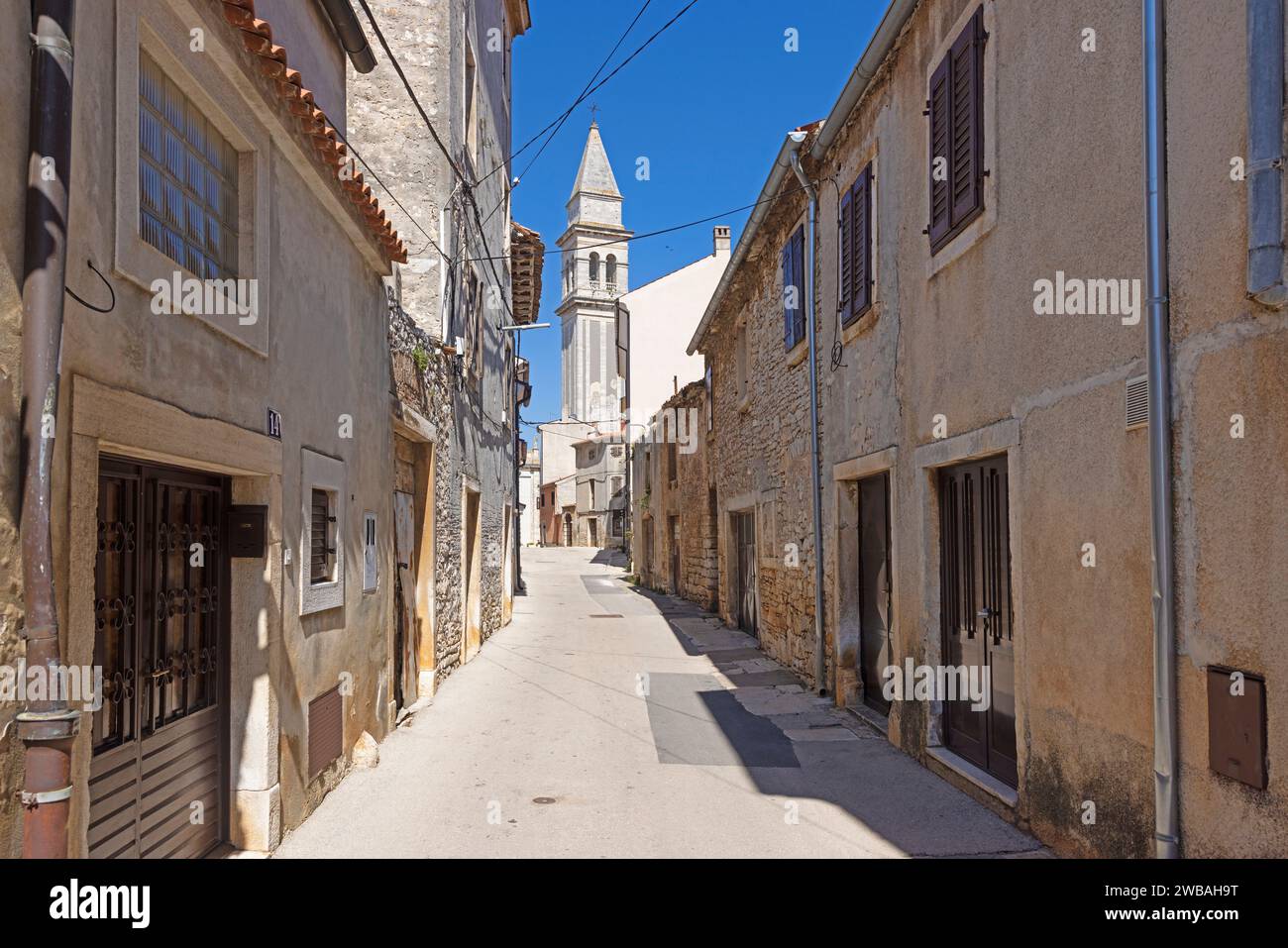 Bild einer typischen Straßenszene aus der historischen kroatischen Stadt Voznjan mit Kopfsteinpflasterstraßen und alten Gebäuden im Morgenlicht Stockfoto