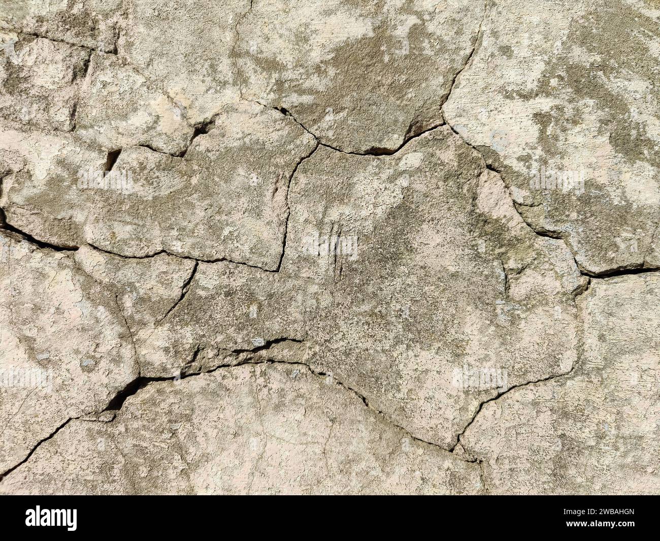 Die Steinmauer eines alten Gebäudes mit zerbröckelndem Putz und vielen gewundenen, tiefen Rissen. Kopierbereich. Selektiver Fokus. Stockfoto Die Steinmauer eines alten Gebäudes mit zerbröckelndem Putz und vielen gewundenen, tiefen Rissen. Kopierbereich. Selektiver Fokus. Stockfoto