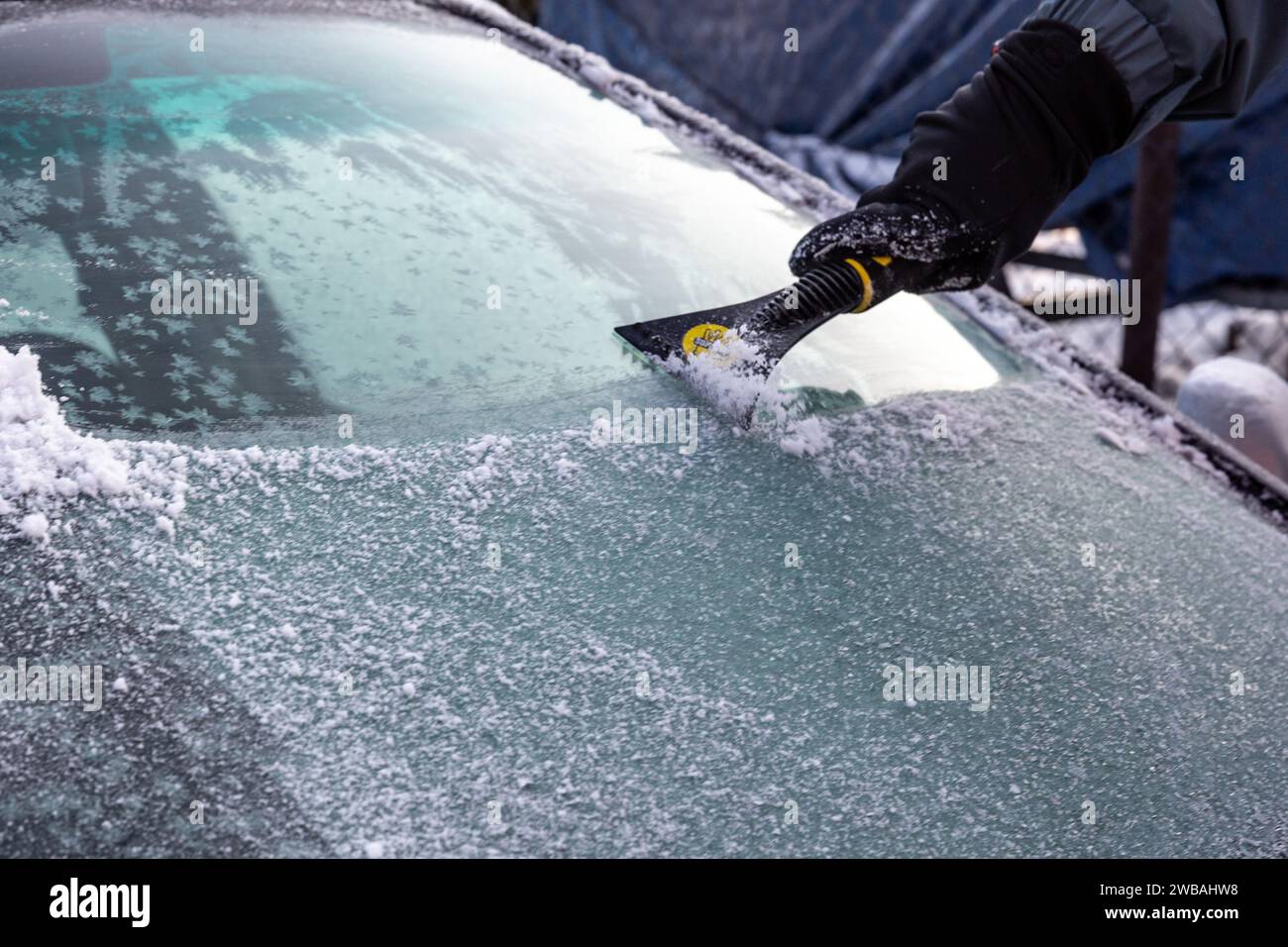 Krakau, Polen. Januar 2024. Ein Mann entfernt Schnee und Eis aus seinem Auto, während die Temperaturen unter Null fielen und Schnee den größten Teil der Stadt bedeckt. (Credit Image: © Dominika Zarzycka/SOPA images via ZUMA Press Wire) NUR REDAKTIONELLE VERWENDUNG! Nicht für kommerzielle ZWECKE! Stockfoto