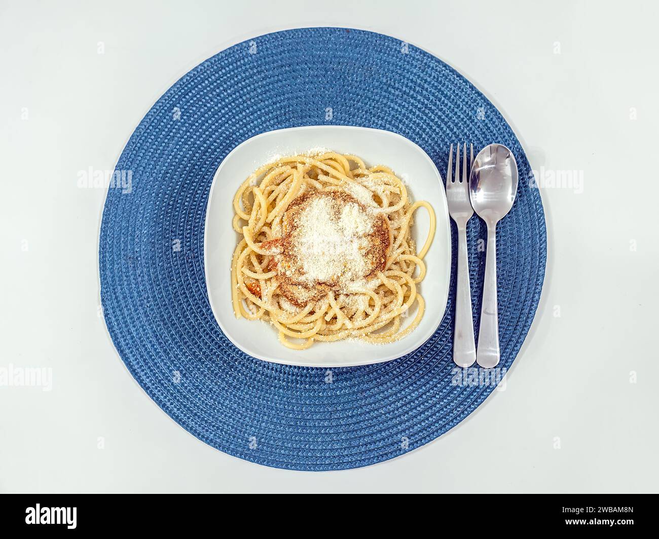 Spaghetti, serviert in einer weißen Schüssel auf einem Tisch, direkt von oben geschossen Stockfoto