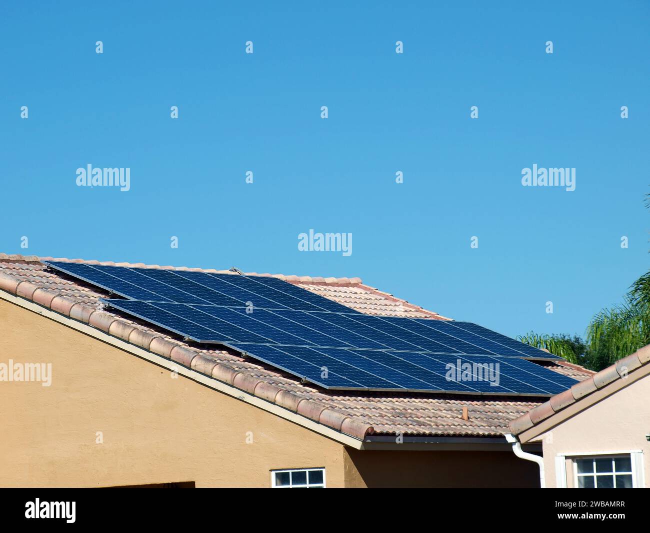 Solarpaneele, die auf einem Dach aus Fliesen eines Wohnhauses installiert sind. Kopierbereich oben. Stockfoto