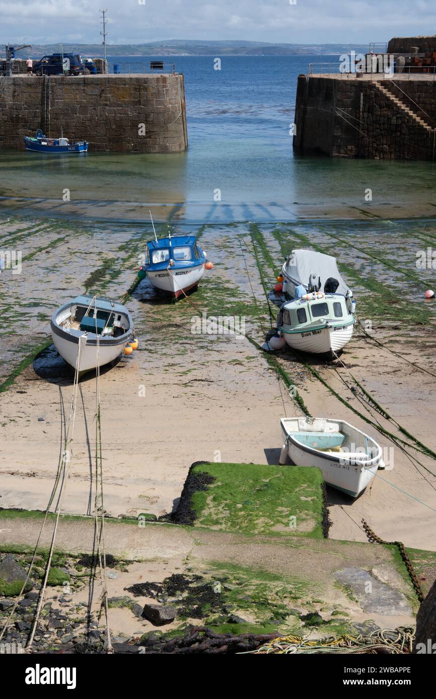 Kleine Boote auf Grund im Hafen von Mousehole bei Ebbe Cornwall England Stockfoto