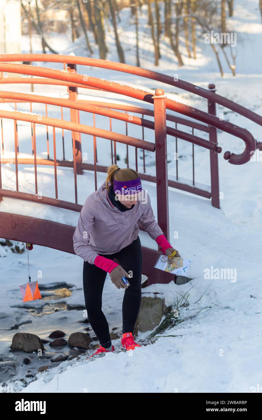 Grodno, Weißrussland - 03. Januar 2024: Junge Mädchen nimmt an einer Orientierungsausbildung im Winter unter städtischen Bedingungen Teil. Kontrollpunkt für Orientierung im Freien Stockfoto