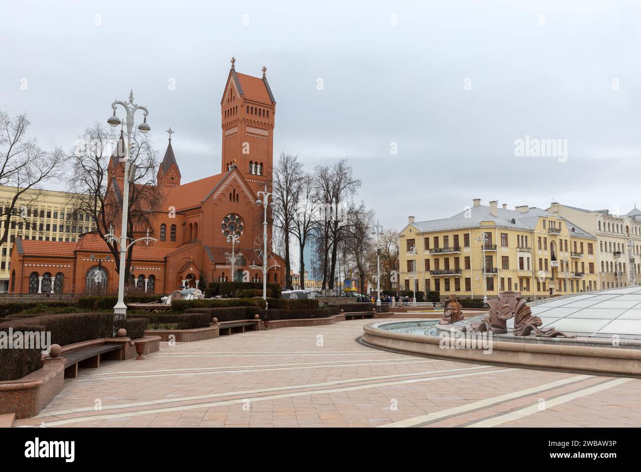 Minsk, Weißrussland - 3. Januar 2024: Blick auf die Unabhängigkeit mit der Roten Kirche im Hintergrund. Touristen laufen die Straße Stockfoto