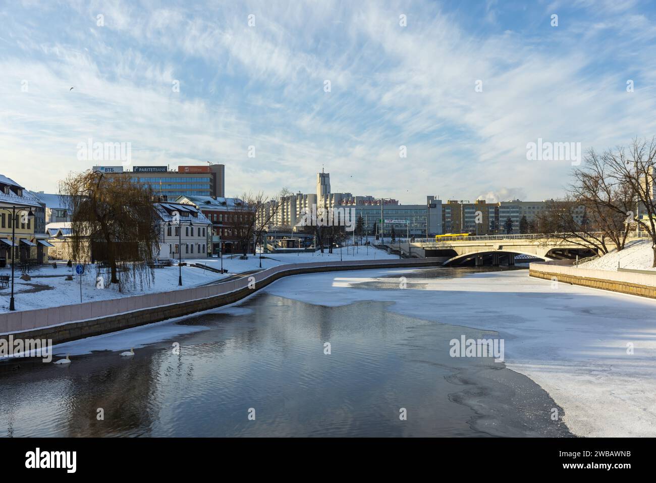 Minsk, Weißrussland - 7. Januar 2024: Stadtbild mit gefrorenem Fluss Svislach und Khlusov-Brücke Stockfoto