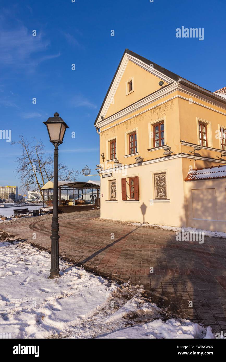 Minsk, Weißrussland - 7. Januar 2024: Dreifaltigkeitsvorort, vertikaler Straßenblick mit alten Wohnhäusern an einem sonnigen Wintertag Stockfoto