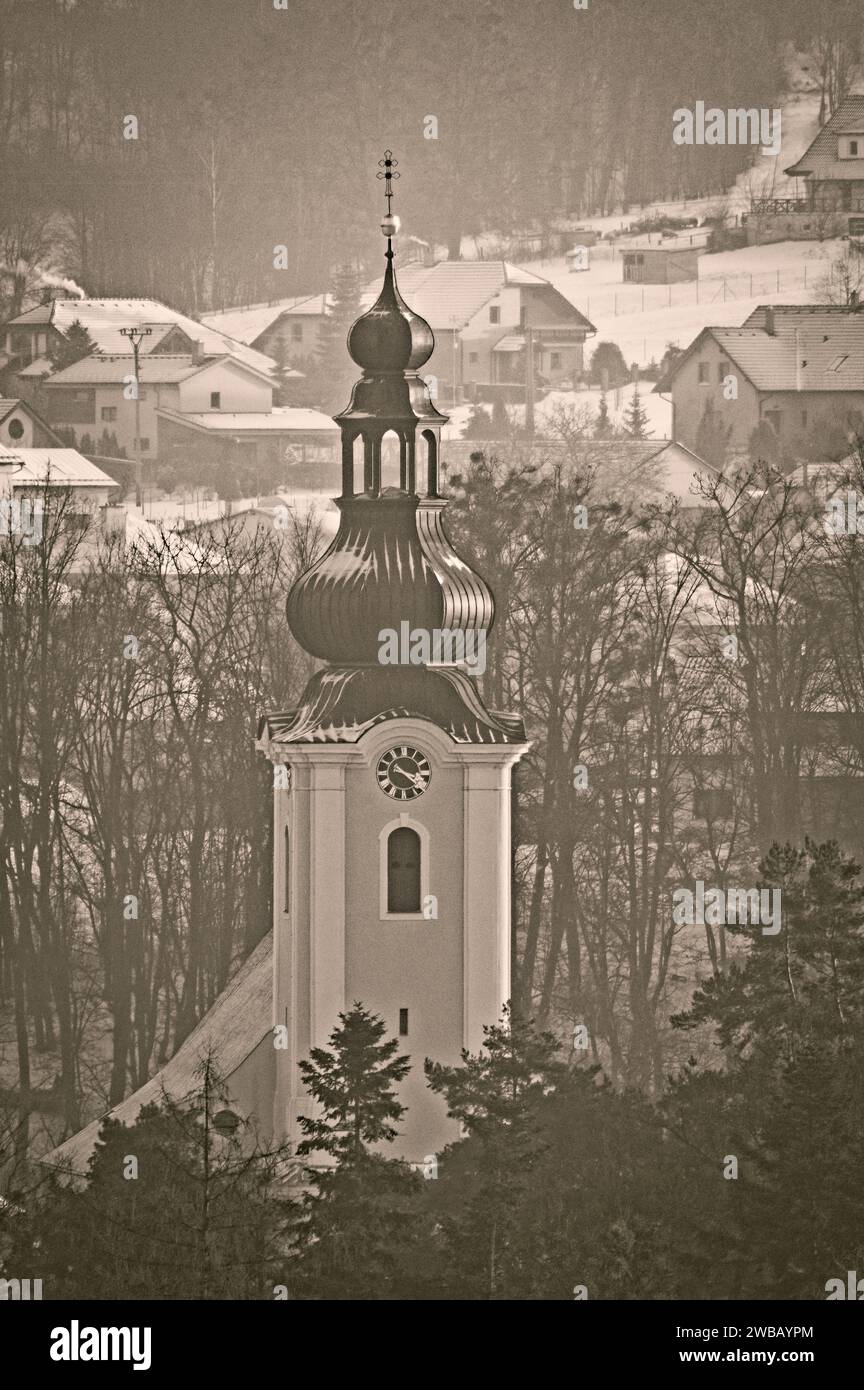 Kirchturm mit Uhr in der kleinen Stadt Roznov Pod Radhostem in Tschechien. Traditionelle Architektur. Retro-Postkarte im Vintage-Stil, bearbeitetes Foto. Stockfoto