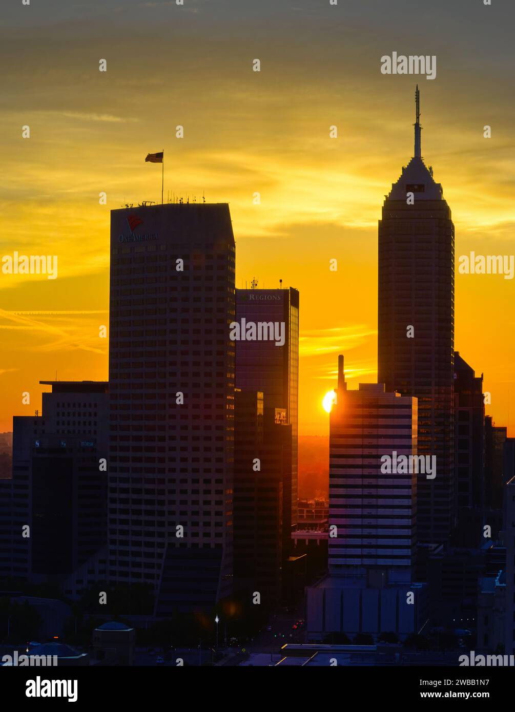 Skyline von Indianapolis bei Sonnenuntergang mit amerikanischer Flagge Stockfoto
