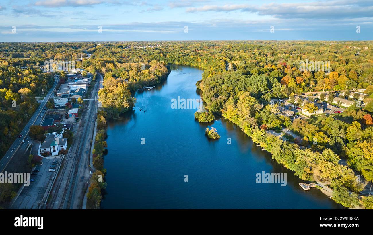 Blick aus der Vogelperspektive auf den ruhigen Fluss und herbstliche Bäume in Small Town Stockfoto