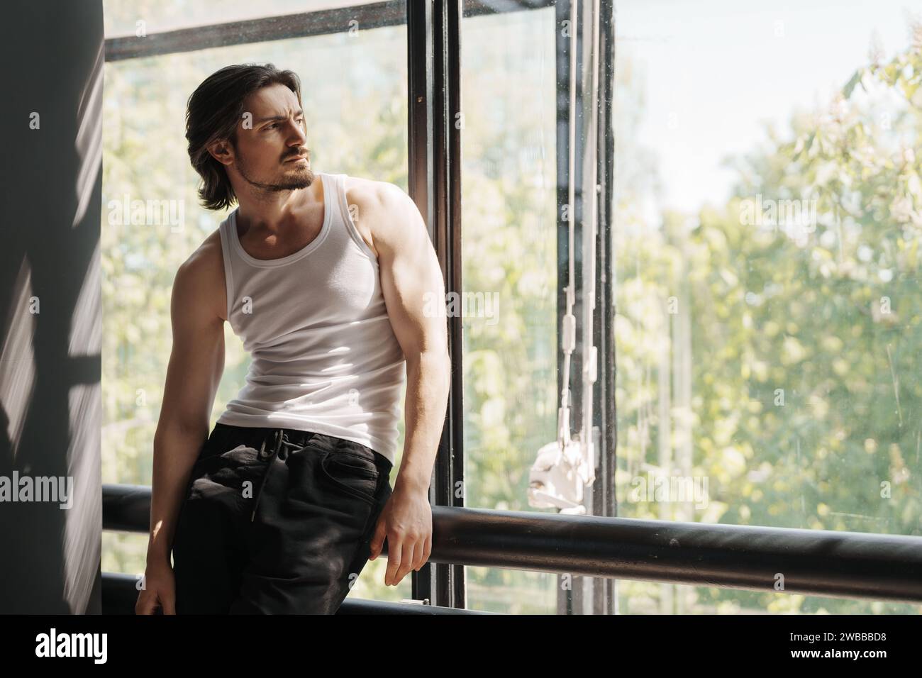 Nachdenklicher Mann durch helles Fenster Stockfoto
