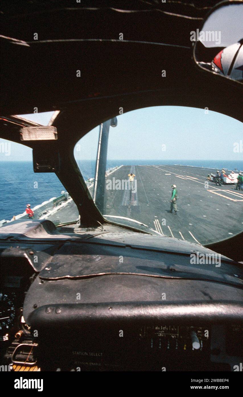 Aus dem Cockpit eines Angriffsgeschwaders 176 (VA-176) KA-6D Intruder-Flugzeugs führt ein Flugzeugdirektor den Piloten zum Katapult Nr. 2 auf dem Flugdeck des Flugzeugträgers USS FORRESTAL (CV 59) 1989 Stockfoto