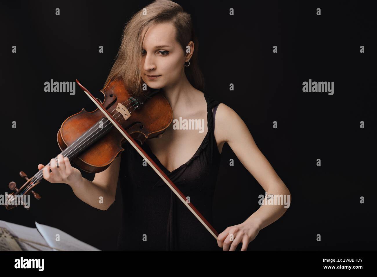 Intimität mit Musik, die durch die sanfte Umarmung der Geige dargestellt wird, und das Wesen der Aufführung einfängt Stockfoto